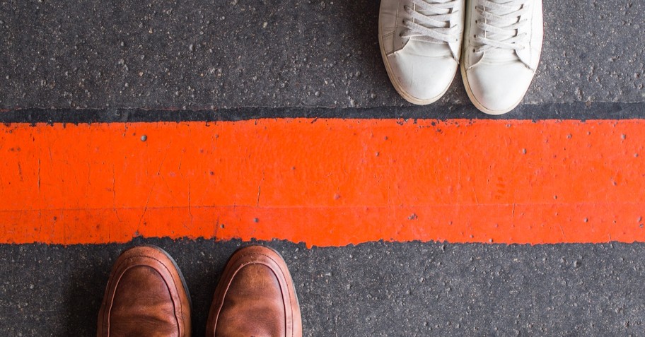 Two sets of shoes on either side of a bright red line