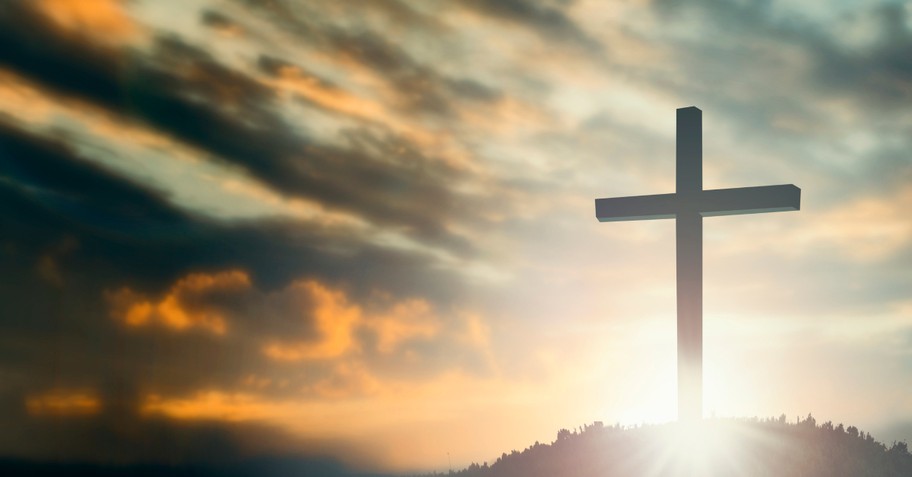 Jesus cross on hilltop sunrays at dusk, what is the holy spirit how does it make us more like jesus