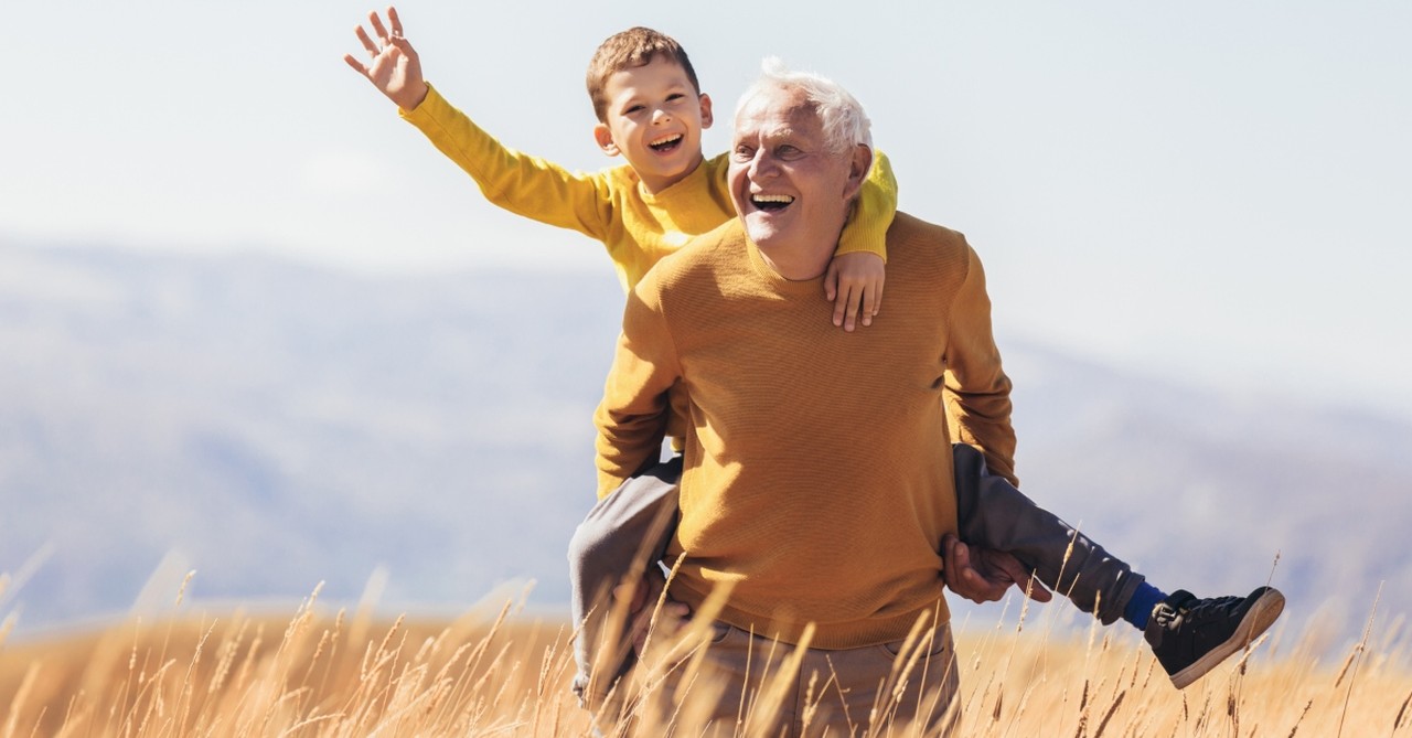 grandparent giving grandson a piggyback outdoors 