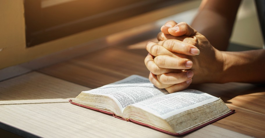 A person praying, thanking god that he is good all the time